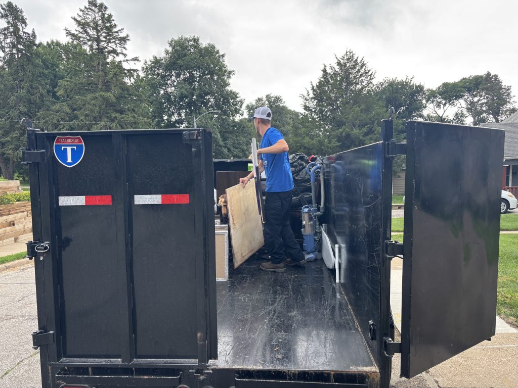 Junk removal team loading unwanted items into a trailer in Omaha, Nebraska.